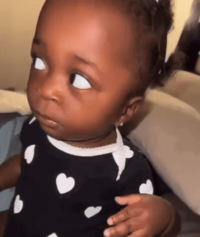 Baby Making Funny Face In Heart Dress GIF