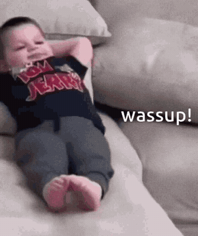 Baby On Couch With Hands Behind Head Saying Wassup GIF