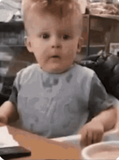 Baby Sitting At Table Making Funny Face GIF