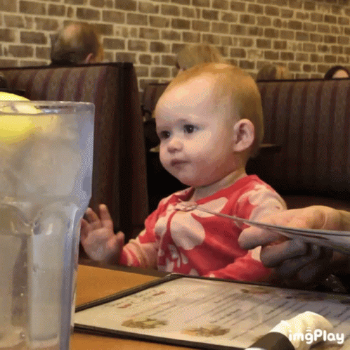Baby Sitting At Table With Menu And Water GIF