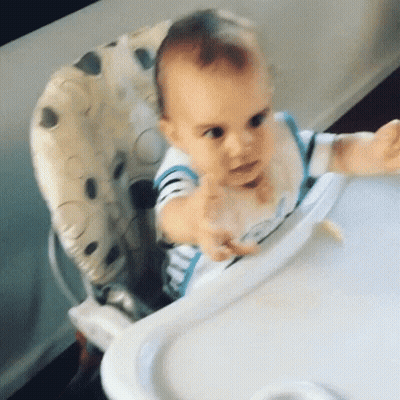 Baby Sitting In High Chair With Spoon In Mouth GIF