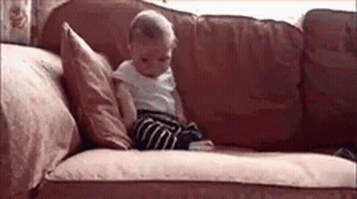 Baby Sitting On Couch With Pillow GIF