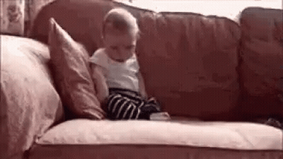 Baby Sitting on Couch With Pillows