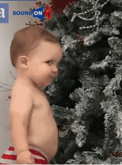 Baby Standing In Front Of Christmas Tree GIF