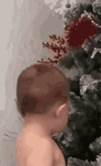 Baby Standing Next To Christmas Tree GIF