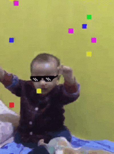 Baby Wearing Sunglasses On Bed In Front Of Yellow Wall GIF