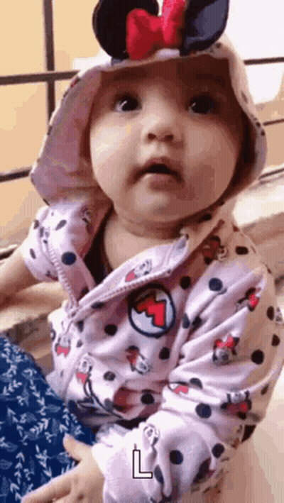 Baby With Bracelet Covering Face GIF