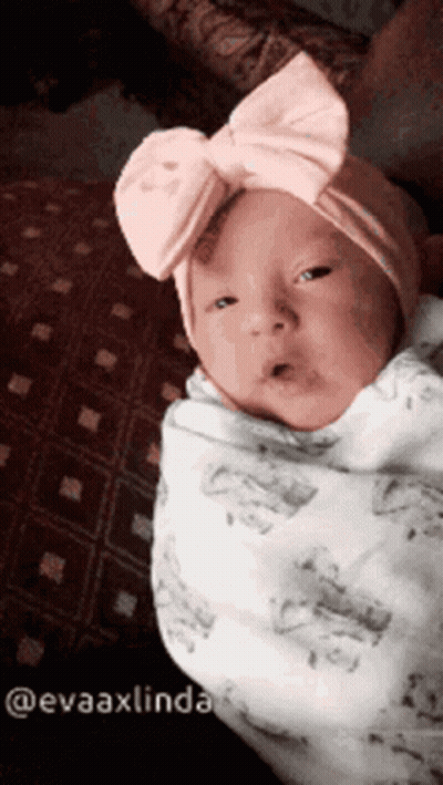 Baby Wrapped In Blanket With Pink Bow Headband GIF