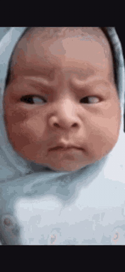 Baby Wrapped In Blue Blanket Making Funny Face GIF