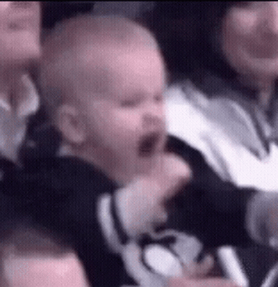 Baby Yawning Held By Woman In Crowd GIF