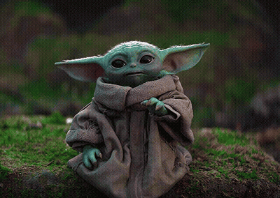 Baby Yoda Figurine Sitting On Mossy Rock GIF
