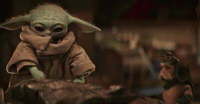 Baby Yoda Toy Sitting on Rock