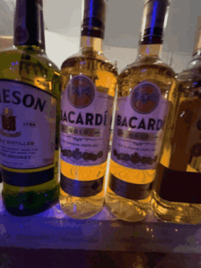 Bacardi Bottles Lined Up On Shelf GIF