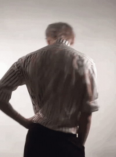 Back Of Man In Striped Shirt And Black Pants With Hands On Hips GIF