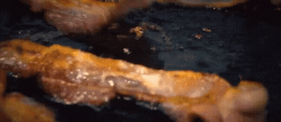 Bacon Is Being Cooked In A Frying Pan On A Stove . GIF