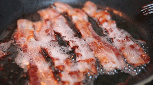Bacon Is Being Cooked In A Frying Pan With Bubbles GIF