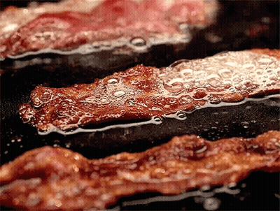 Bacon Is Being Cooked In A Frying Pan With Bubbles Coming Out Of It GIF