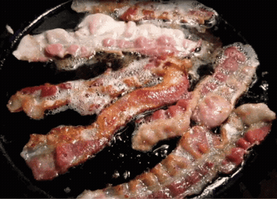 Bacon Is Being Cooked In A Skillet With Bubbles Coming Out Of It GIF