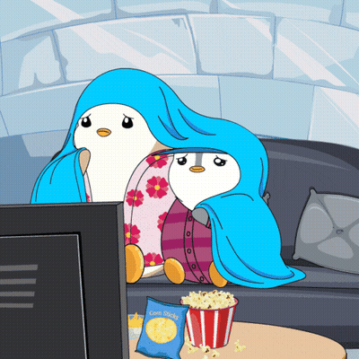 Bag Of Corn Sticks Beside Two Penguins In Blankets GIF
