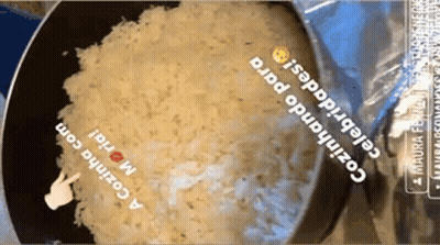 Bag Of Rice Being Cooked In Frying Pan With Hand Pointing GIF