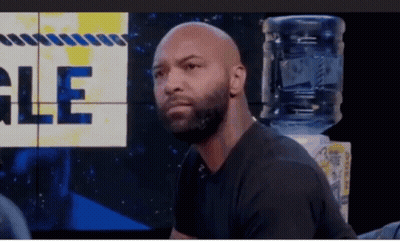 Bald Bearded Man Sitting In Front Of Gle Wall GIF