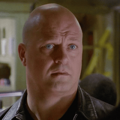 Bald Man Blue Eyes Black Jacket Looking At Camera GIF