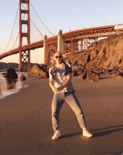Bald Man Dancing On Beach GIF