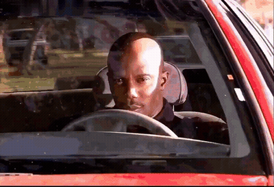 Bald Man Driving Red Car Looking Out Window GIF