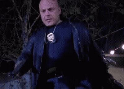 Bald Man In Black Jacket Holding Police Badge GIF