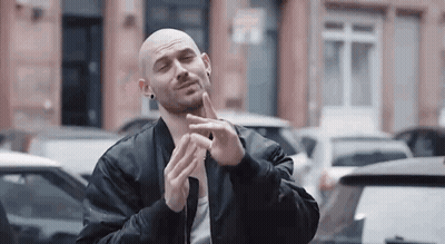 Bald Man In Black Jacket Making Funny Face In Parking Lot GIF