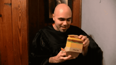 Bald Man In Black Robe Opening Big Mac GIF