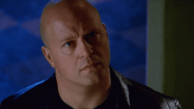 Bald Man In Black Shirt And Leather Jacket Looking At Camera GIF