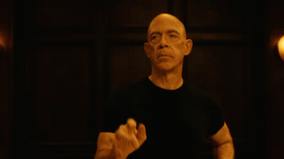 Bald Man In Black Shirt Raising Hand GIF