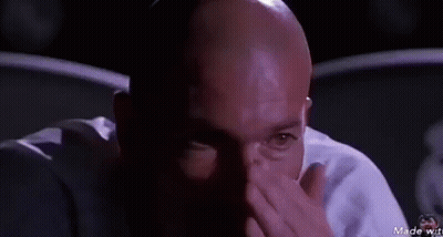 Bald Man In Dark Room Looking At Camera GIF