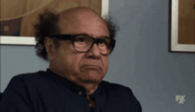 Bald Man In Glasses And Blue Shirt Sitting GIF