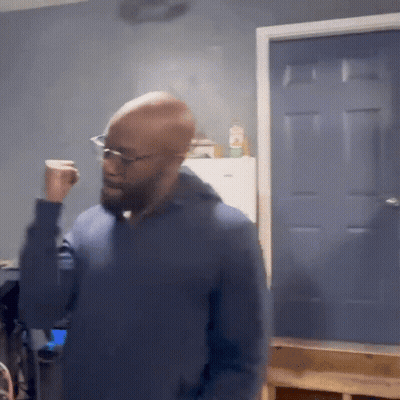 Bald Man In Glasses And Blue Sweater At Blue Door GIF