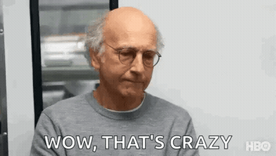 Bald Man In Glasses And Gray Sweater Saying Wow At Window GIF