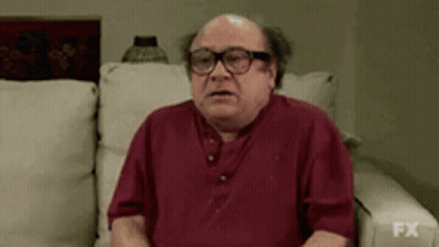 Bald Man In Glasses And Red Shirt Sitting On Couch GIF