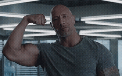 Bald Man In Gray Shirt Flexing Muscles GIF