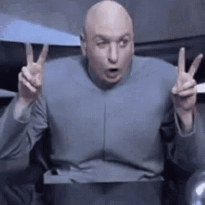 Bald Man In Gray Suit Giving Peace Sign GIF