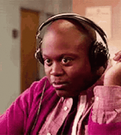 Bald Man In Headphones And Pink Shirt On Couch GIF