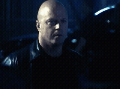 Bald Man In Leather Jacket Looking At Camera GIF