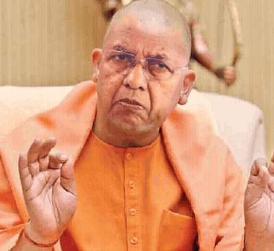 Bald Man In Orange Shirt And Glasses Sitting On Couch GIF
