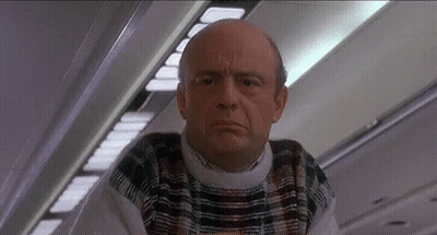 Bald Man In Plaid Sweater On Airplane GIF