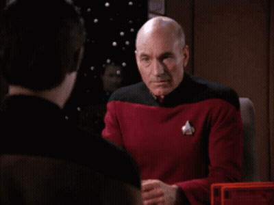 Bald Man In Red And Black Uniform Covering Face GIF