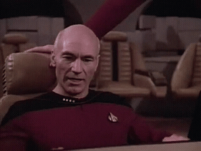 Bald Man In Red Shirt Sitting With Arms Outstretched GIF