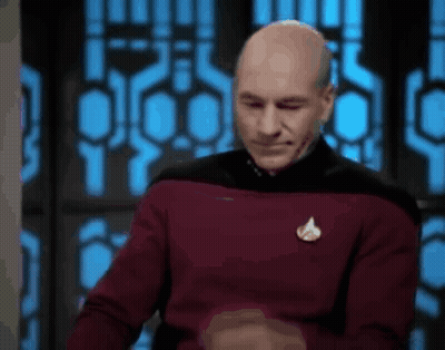 Bald Man In Red Sweater Making Funny Face By Window GIF