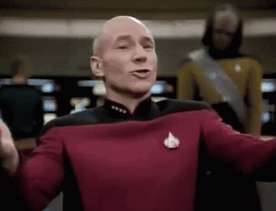 Bald Man In Red Uniform Arms Outstretched Before Crowd GIF