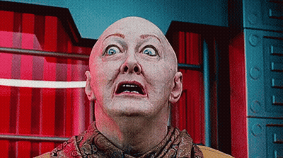 Bald Man In Scarf Looking Up At Camera GIF