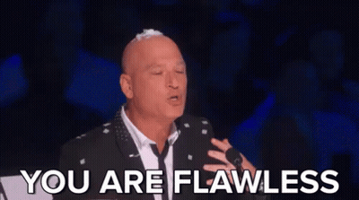 Bald Man in Suit and Tie at Microphone